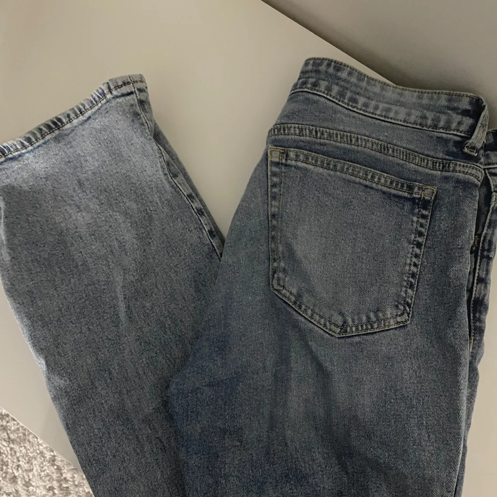 Säljer ett par klassiska blå jeans i bra skick. De har en normal passform och är perfekta för vardagsbruk. Jeansen har en knapp och dragkedja framtill samt fem fickor. Perfekta för både höst och vår!. Jeans & Byxor.