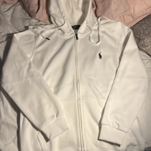 Vit hoodie från Polo Ralph Lauren - Säljer en skön raffe zip! Storleken är L men är liten i storlek så passar M-S. Priset kan diskuteras vid snabb affär!