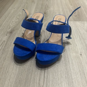Blå sandaler med klack - Snygga blå sandaler med klack och breda remmar. Perfekta för sommarens fester eller en dag på stan. De har en bekväm passform och en stilren design som passar till många olika outfits.