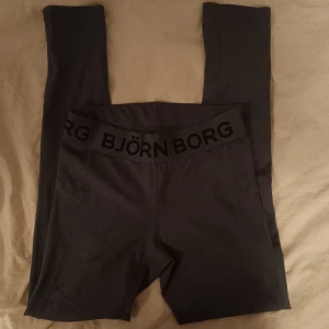 Turkosa tights från Björn Borg - Säljer ett par turkosa tights från Björn Borg i storlek S. De är i mycket bra skick och har en bekväm passform med elastisk midja och snörning. Perfekta för träning. Färgen syns ej bra på bild men det är en väldigt fin mörkare turkos färg