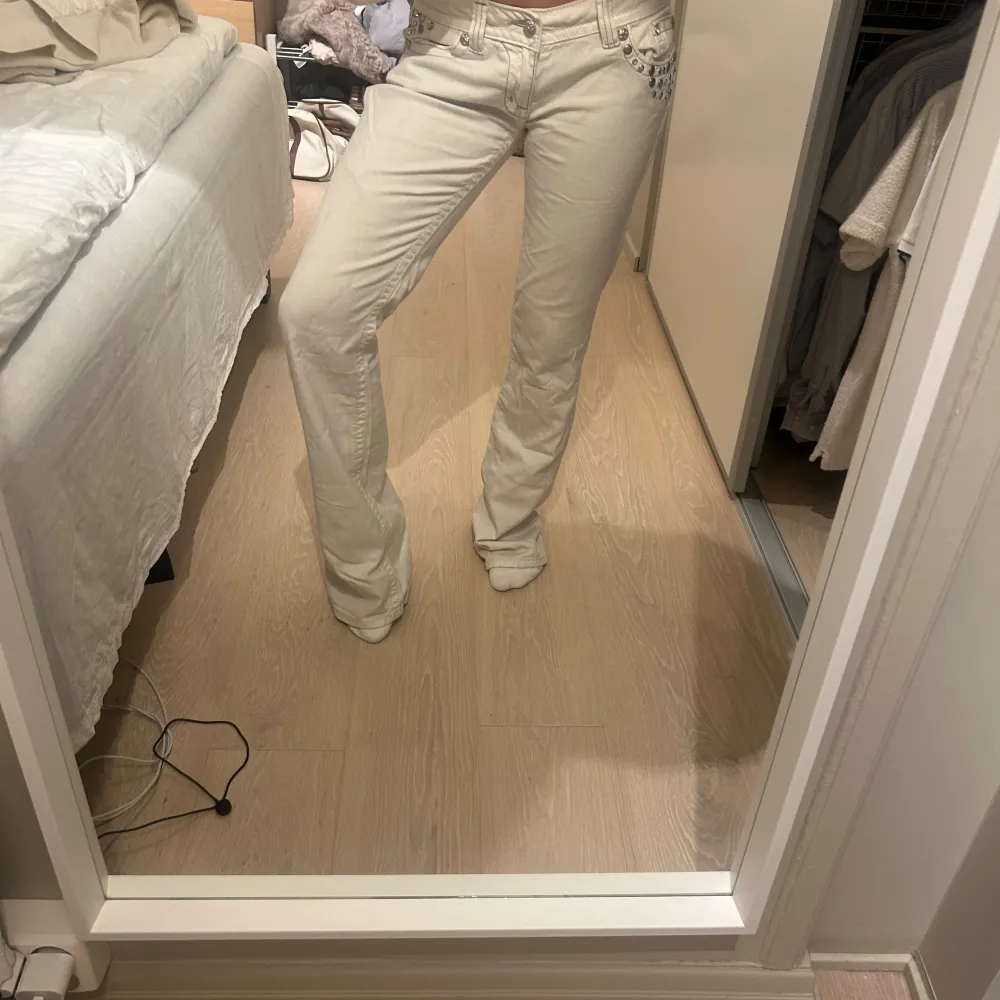 Säljer ett par snygga beige jeans med coola detaljer på bakfickorna. De är i bra skick och har en normal passform. Perfekta för höst och vår! 🕶️. Jeans & Byxor.