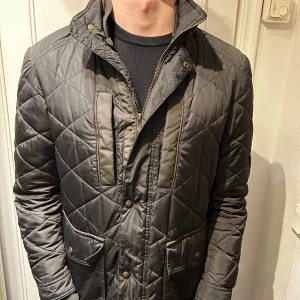 Massimo dutti jacka  - Säljer en snygg grå quiltad jacka i mycket bra skick. Den har en dragkedja och knappar framtill, samt praktiska fickor. Perfekt för höst och vår när det är lite kyligare ute. Jackan har en normal passform och är långärmad. En stilren och tidlös design som funkar till det mesta!