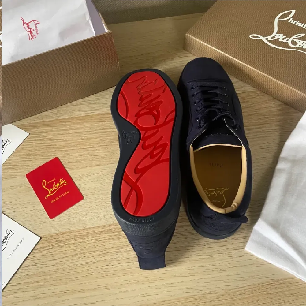 Säljer ett par snygga svarta sneakers från Louboutin i nytt skick. Skorna har en ikonisk röd sula och är gjorda i skinn. Perfekta för både vardag och fest! Kommer med originalförpackning och certifikat.. Skor.