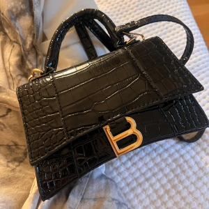 Svart krokodilpräglad handväska med gulddetaljer - Säljer min fina väska, inget kvitto då den var en gåva. Därav lågt pris. 