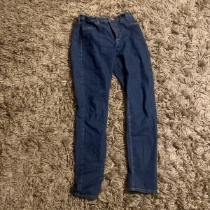 Blå skinny jeans - Snygga blå skinny jeans i denim med elastisk midja. Perfekta för en stilren look och bekväma att bära hela dagen. Passar utmärkt till olika outfits och tillfällen.