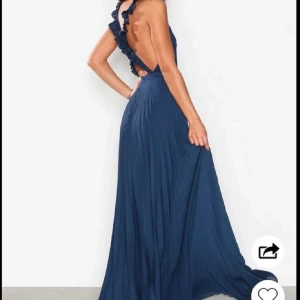 Mörkblå långklänning med öppen rygg - Fin mörkblå långklänning med en stilren design och öppen rygg. Perfekt balklänning! Använd två gånger 