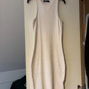 Vit ribbad klänning från new yorker - Säljer en  vit ribbad klänning från mew yorker. Den är ärmlös och har en tight passform som framhäver figuren. Perfekt för varma sommardagar🌸