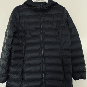 Dunjacka, Eddie Bauer, L, svart - Svart lättvikt dunjacka från Eddie Bauer i mycket fint skick. Storlek L.   Material:  Yttre och inre 100% recycled nylon Fyllning 90% down, 10% waterfowl feathers  Mått: Längd ca 75 cm Midja ca 50 cm Byst ca 55 cm Ärmlängd mätt från axeln ca 62 cm