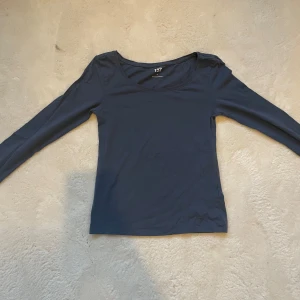 Blå tröja  - Det är en vanlig blå lång ärmad tröja ”Stockholms still ”