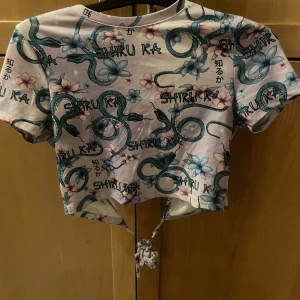 Lila tröja med ormar - En fin lila tröja med gröna ormar och öppen rygg och knyte runt