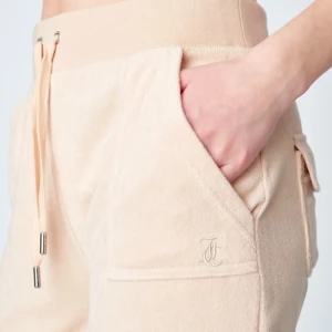 Beige mjukisbyxor från Juicy Couture🧸 - Säljer ett par bekväma beige mjukisbyxor med snörning i midjan och praktiska fickor. Byxorna har en avslappnad passform och är perfekta för en chill dag. Det är frotté tyg och inte sammet.De är fint uppsydda och passar för kortare ben👌💓Inga defekter!  Pris kan diskuteras.