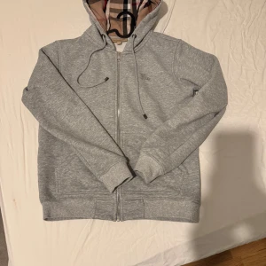 Grå Burberry hoddie - Säljer en stilren grå Burberry hoddie för ett riktigt bra pris. Sitter riktigt bra som M men funkar även som S. priset kan diskuteras
