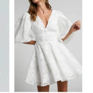 Vit klänning med puffärmar från Showpo - Helt ny klänning från Showpo. Aldrig använd och lappen kvar. Helt slutsåld på hemsidan. Ordinarie pris 1350kr inklusive frakten.