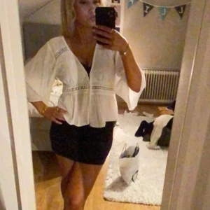 Vit blus - Snygg vit blus med trekvartsärmar och dekorativa spetsdetaljer. 