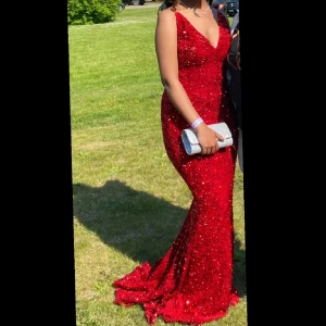 Röd glittrig långklänning - Säljer en fantastisk röd glittrig långklänning med djup v-ringning och smala axelband. Perfekt för balen! Väldigt bra skick och är använd endast 1 gång. Den är storlek Xs men skulle nog säga att den även passar S. Skriv vid funderingar💓💓 Pris kan även diskuteras☺️