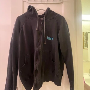 Svart KENT Hoodie - Svart kent tröja med dragkedja framtill. Köpt merch från 2005. Något urtvättad. Storlek M. I överliggande fint skick kring muddar och resår.
