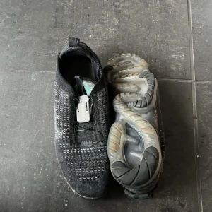 nike vapor max - Snygga svarta Nike Flyknit sneakers med en unik stickad design och flexibel sula. Perfekta för både träning och vardag. De har en smidig passform utan snörning för enkel på- och avtagning.