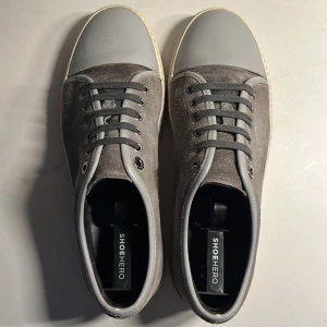 Grå sneakers från lanvin - Snygga grå sneakers från lanvin med mocka. Skorna har en stilren design med snörning och en ljus sula som ger en modern touch. Storlek uk 6 men passar 42-43