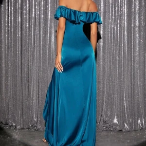 Turkos långklänning med volang - Säljer en elegant turkos långklänning i satin med offshoulder-design och volangdetaljer. Klänningen har en smickrande slits framtill och är perfekt för festliga tillfällen. 