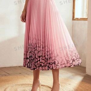 Rosa plisserad kjol från SHEIN - Superfin rosa plisserad kjol från SHEIN med ett vackert blommönster längst ner. Kjolen har en elegant ombre-effekt som går från ljusrosa till mörkare nyanser. Perfekt för vår och sommar, och funkar både till vardags och fest. Den är i ett lätt och luftigt material som ger en skön känsla.