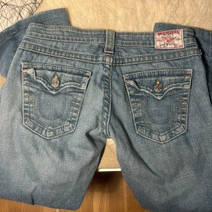True Religion jeans i ljusblå denim - Säljer ett par snygga True Religion jeans med coola bakfickor. De är i mycket bra skick och storlek 27. De är tyvärr något korta för mig som är 168cm (innerbenslängden är 74cm). 