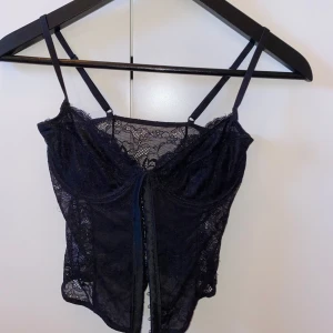 Svart spetskorsett - En svary korsett från Na-kd. Lappen har jag klippt bort, använt den ett fåtal gånger. Den är i storlek 34, funkar för någon som har kupa 75a/b. 