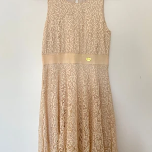 Beige spetsklänning från Chiara Forthi - Säljer en superfin beige spetsklänning från Chiara Forthi köpt på Bubbleroom. Klänningen är ärmlös och har ett vackert spetsmönster över hela tyget. Den har en elegant midjebanddetalj med en liten metallplatta 💖XS men passar S.
