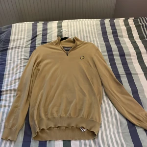 Beige tröja från Lyle & Scott - Säljer en snygg beige tröja från Lyle & Scott i storlek L. Tröjan har en dragkedja vid halsen och det klassiska Lyle & Scott-logotypen på bröstet. Perfekt för både höst och vår. Den är i mycket bra skick och passar till både vardag och fest. Pris går alltid att förhandla!
