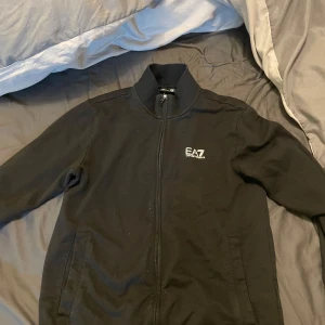 Ea7 tröja - Tjaba, säljer denna fina ea7 zip up, använd endast 3 gånger och säljs då jag rensar i hemmet, fint skick och inget fel på tröjan. Köpt för 1300kr säljs billigt då jag rensar i hemmet och därför säljs för billig peng! Vid fler frågor kom pm!