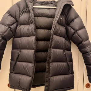 Svart dunjacka från Peak Performance - Säljer en svart dunjacka från Peak Performance i mycket bra skick. Jackan är perfekt för vintern med sin varma och puffiga design. Jackan är 2 år gammal men varsamt använd. Kvitto finns