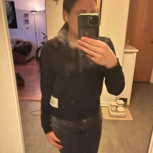 Svart tröja från Calvin Klein - Säljer en svart tröja från Calvin Klein i mycket bra skick. Den har en enkel design med en vit logga på framsidan. Perfekt för både vardag och avslappnade tillfällen. Tröjan är långärmad och har en normal passform.