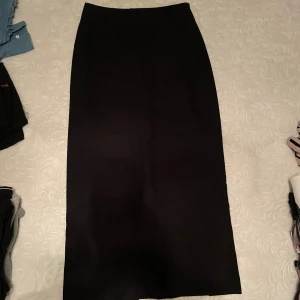 Lång kostymkjol  - Snygg svart kostymkjol i mycket bra skick. Endast använd 3-4 gånger. Den kommer ner till hälarna för mig som är 160cm. 