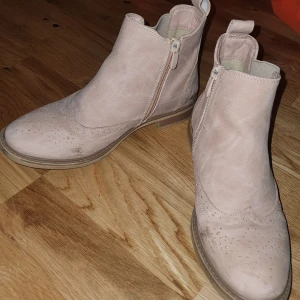 Boots - Säljer ett par snygga beige boots. De har en klassisk design med perforerade detaljer på tån och en låg klack. Perfekta för höst och vår! 🥿 Lite smutsiga men annars inga defekter 