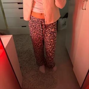 Leopardmönstrade byxor från H&M - Säljer ett par superbekväma leopardmönstrade byxor från H&M i storlek XS. De är loose fit och perfekta för en avslappnad dag hemma eller en chill kväll med vänner. Byxorna har en elastisk midja med snörning för extra komfort. 🐆