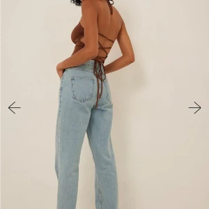 Brun halterneck topp från NA-KD - prislapp på - Snygg brun halterneck topp från NA-KD med smala band som knyts i ryggen. Toppen är croppad och har en tight passform, perfekt för sommardagar eller en utekväll. Materialet är mjukt och stretchigt för en bekväm känsla. Aldrig använd med prislappen på. 