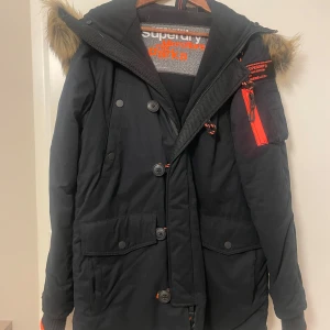 Ny Superdry Parka strl M - Säljer en Superdry parka jag köpte till min son men som aldrig använts. Helt i nyskick! Nypris 2500kr