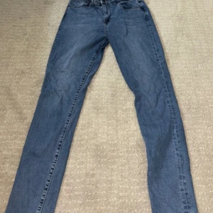 Blå jeans från Levi's - Säljer ett par snygga blå Levi's jeans i modellen 721 High Rise Skinny. De är i bra skick och har en klassisk femficksdesign med en hög midja. Perfekta för både vardag och fest! 💙