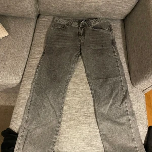 Mörkgrå jeans - Mörkgrå jeans ifrån BoohooMan i lite mer lös passform. Dem är använda men i bra skick, enbart ett litet märke vid fickan och ett litet hål i ena fickan. Jeansen är i storlek 30 och passar mig bra som är 180. 