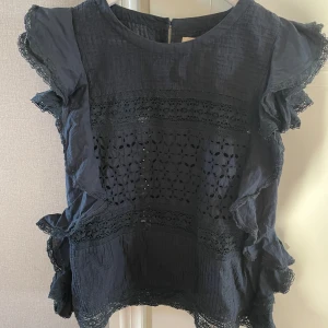 Svart blus från Ralph Lauren - Säljer denna svarta blus från Ralph Lauren i storlek M. Blusen har vackra spetsdetaljer och volanger, passar perfekt både till vardag och fest! 🖤