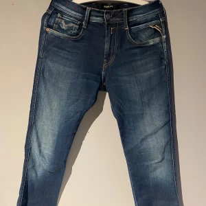 Blå jeans från Replay - Säljer ett par snygga blåa Replay jeans i mycket bra skick . Jeansen är i en slim passform och har en bekväm midwaist. Perfekta för både vardag och fest!