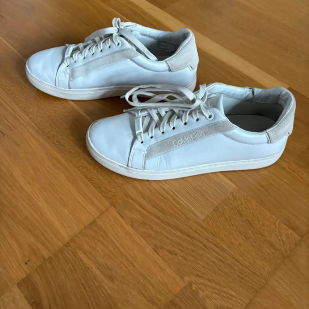 Vita Calvin Klein sneakers i storlek 39, fint skick, dock några skavanker (se bilder)! Väldigt sköna och mjuka! Inte alls gamla, nypris 1000kr. Skor.