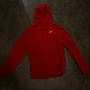 Röd hoodie från Nike - Säljer en snygg röd hoodie från Nike i storlek S. Perfekt för höst och vinter med sin varma och bekväma design. Den har en klassisk Nike-logga på bröstet och en praktisk huva med dragsko. Passar både till vardags och träning!