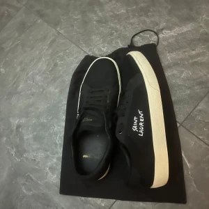 Svarta sneakers från Saint Laurent - **Till salu: Yves Saint Laurent skor**  Snygga och stiliga Yves Saint Laurent skor i utmärkt skick! Perfekta för både vardag och fest.   - **Pris:** 3200 kr (prutbart) - **Kommer med äkthetsbevis**  Passa på att göra ett klipp! Kontakta mig för mer information eller för allmänna frågor!