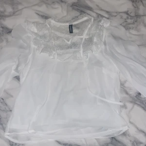 Blus från H&M - Hej! Jag säljer den här jätte fina blusen från hm! Jag har använt ca en gång, den är lite genomskinlig och har lite spets längst upp. Perfekt till sommarn eller ha som fest blus!