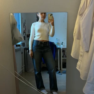 Vit ribbad croppad tröja - Säljer en stilren vit ribbad tröja med croppad passform. Tröjan har långa ärmar och är perfekt för en trendig look. Passar bra till jeans eller kjol för en avslappnad stil.