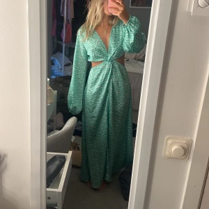 Grön långklänning med cut out  - Snygg grön långklänning med ett  mönster och cut out . Perfekt för sommaren, från hm men slutsåld 