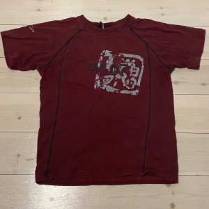 Vinröd t-shirt med tryck - Säljer en vinröd t-shirt med ett unikt tryck på framsidan. T-shirten är i barnstorlek men passar som xs.