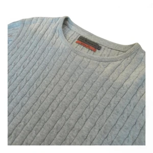 Ljusblå stickad tröja från S.C.W. - Säljer en stilren ljusblå stickad tröja från G.C.W. med kabelstickat mönster. Tröjan har en rund halsringning och långa ärmar, perfekt för kyligare dagar. Passar bra till både jeans och chinos.