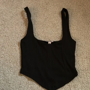 Svart ribbad linnetopp - Snygg svart ribbad linnetopp med breda axelband och fyrkantig urringning. Storlek xs, aldrig använd ❤️