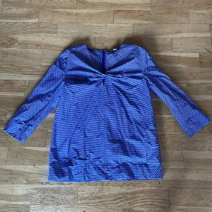 Blå och vit mönstrad blus från COS - Säljer en snygg blå och vit mönstrad blus från COS.  Ny pris är ca 1000kr. Toppen har trekvartsärmar och ett unikt vågigt mönster. Med en fin tvistad detalj på bröstet. Perfekt för en stilren look. Priset kan diskuteras.🫶
